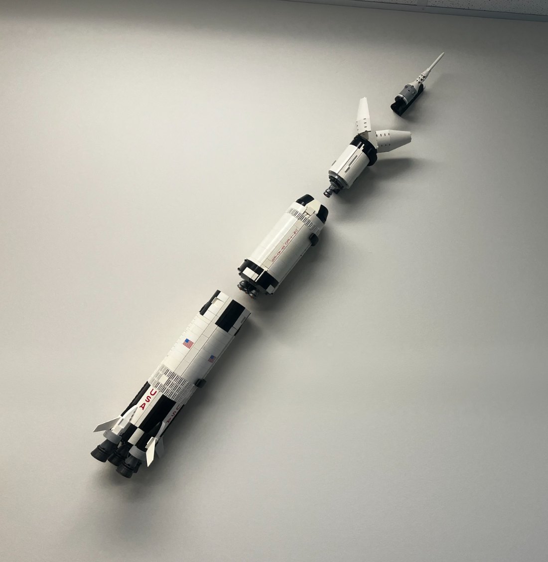 My LEGO Saturn V, taken apart into its stages and laid out on a diagonal